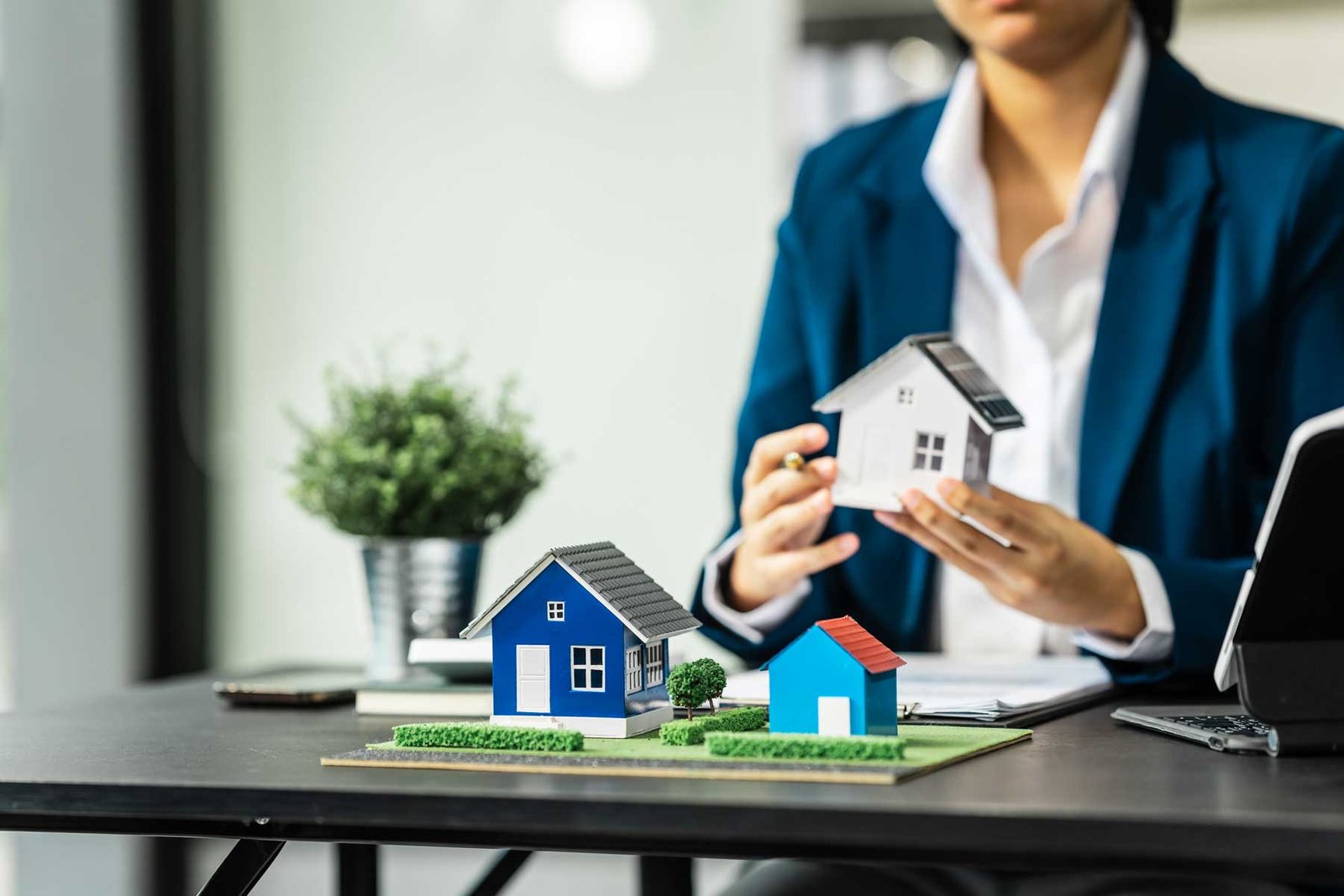 persona sosteniendo una maqueta de casa